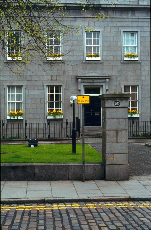 A grey granite town house with white sash windows and railings in Aberdeen