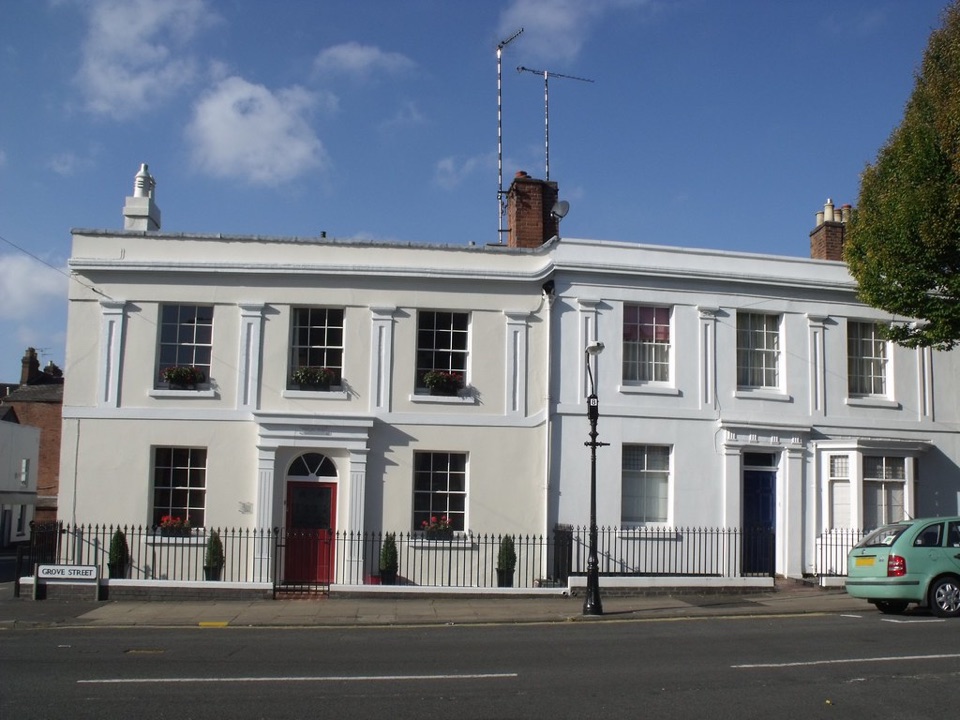 White painted Georgian houses behind railings on an English street